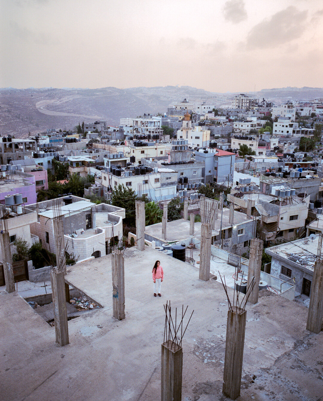 Rooftops and buildings extending across a hillside.