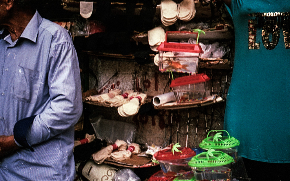 A shop interior with stacked goods and part of a figure.