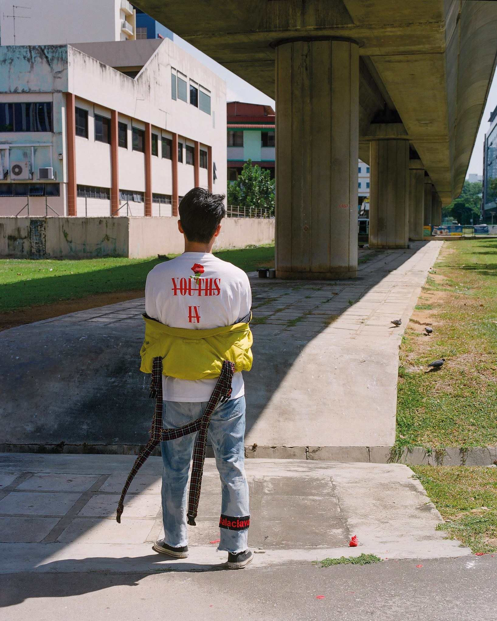 A figure seen from behind beneath an elevated railway.