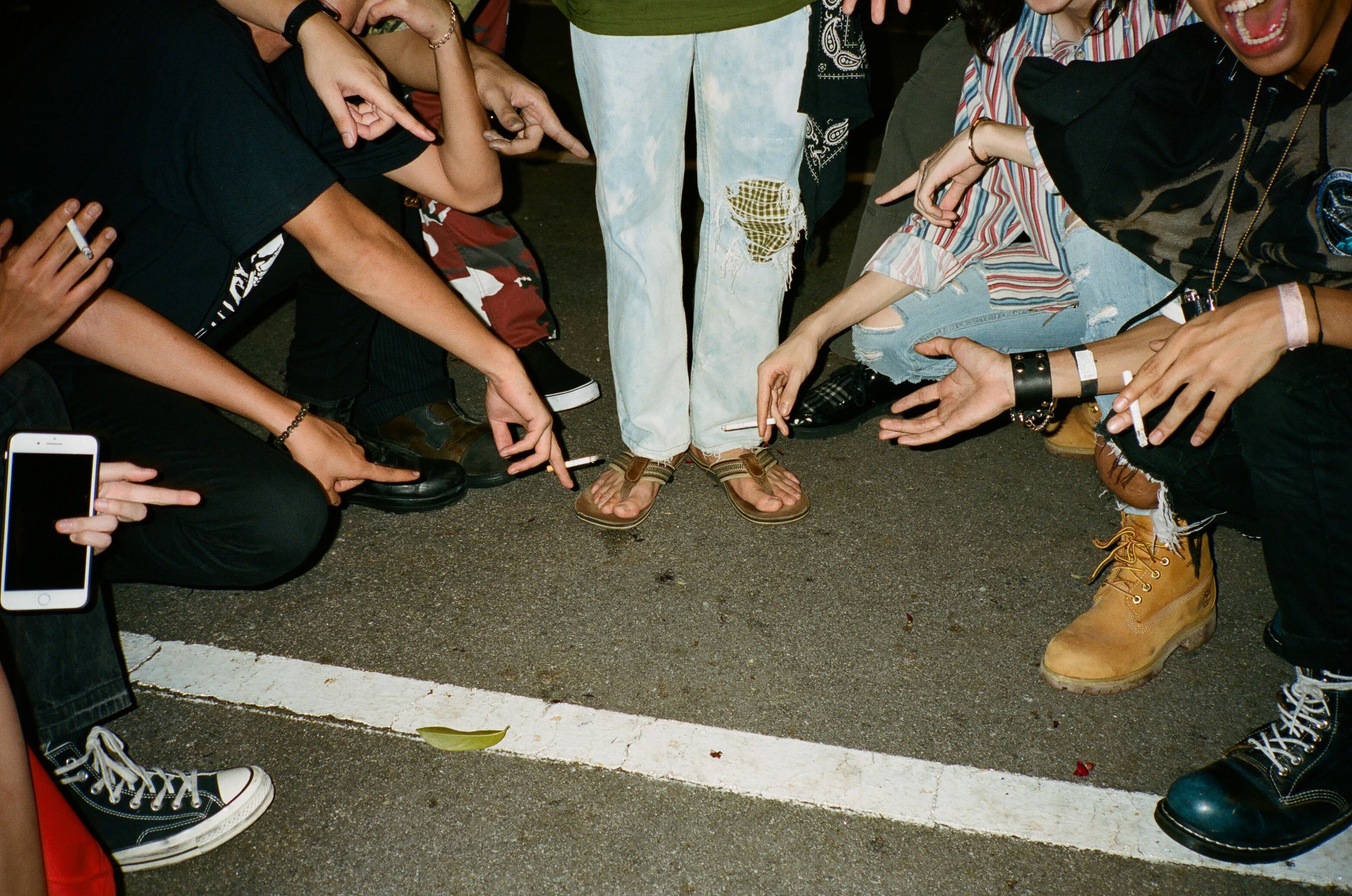 A circle of shoes and pointing hands.