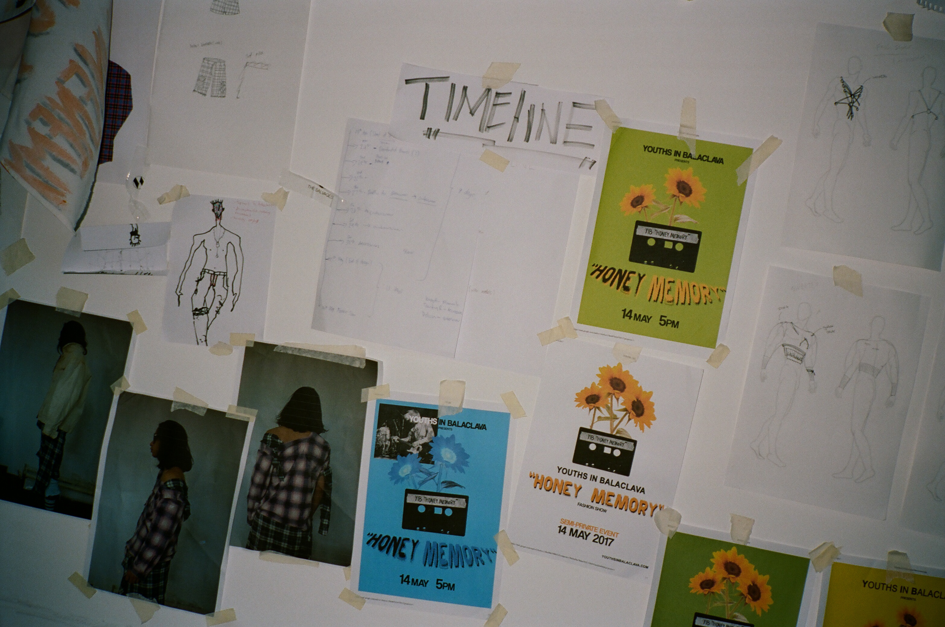 Studio drawings, photographs and Honey Memory posters taped to a wall.