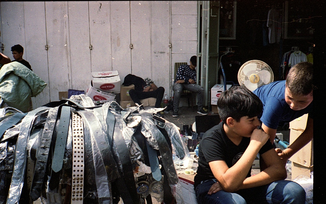 Two people at work among curved metal pieces.