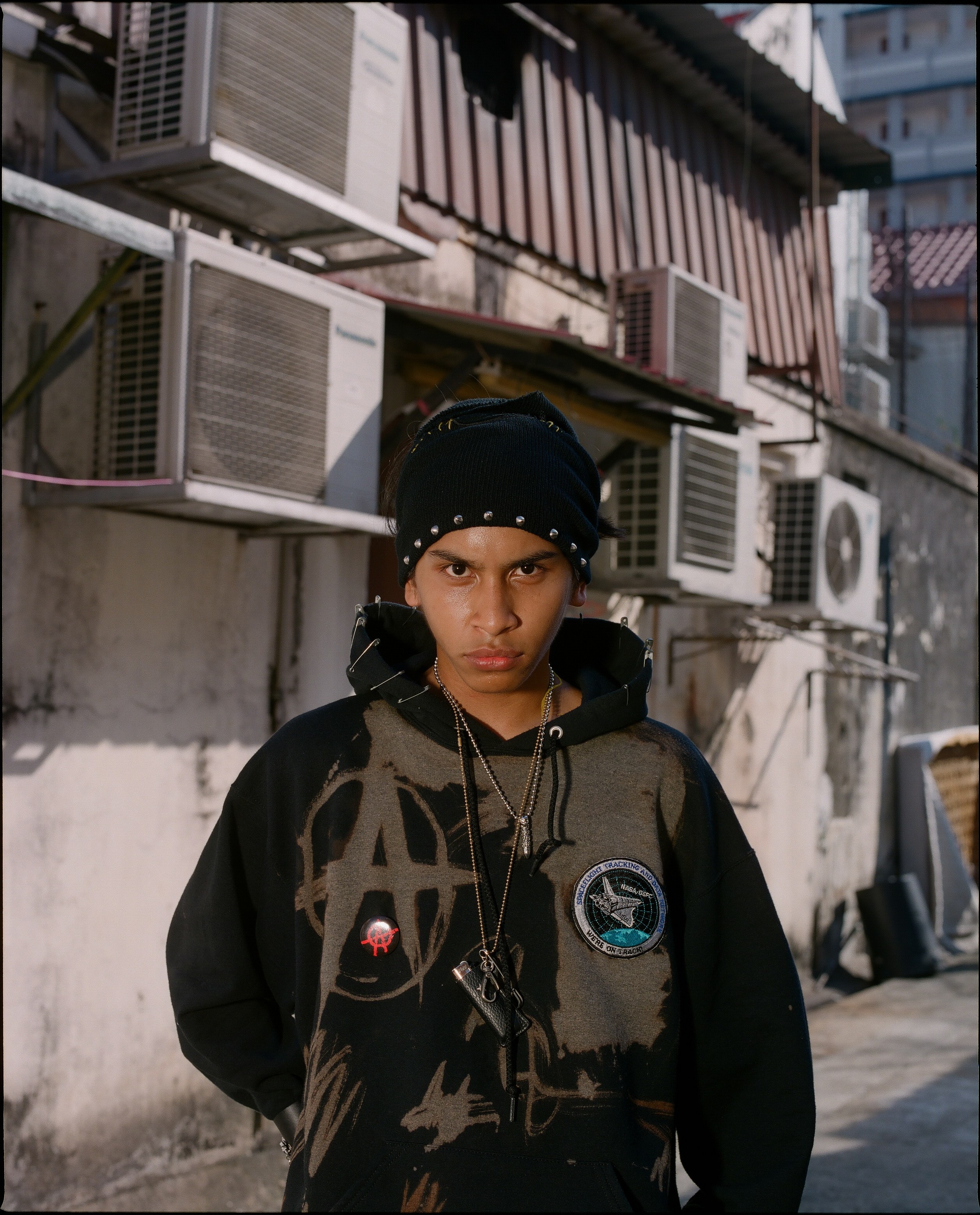 Kash in a patched black hoodie.