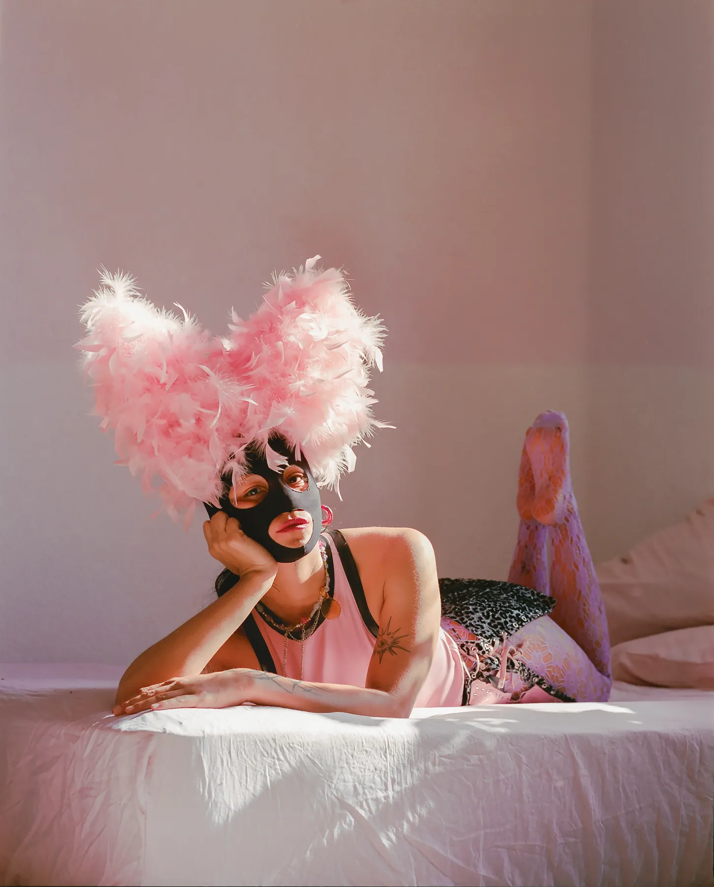 DIABLA DIABLURA, a reclining masked portrait with a pink feather headpiece.