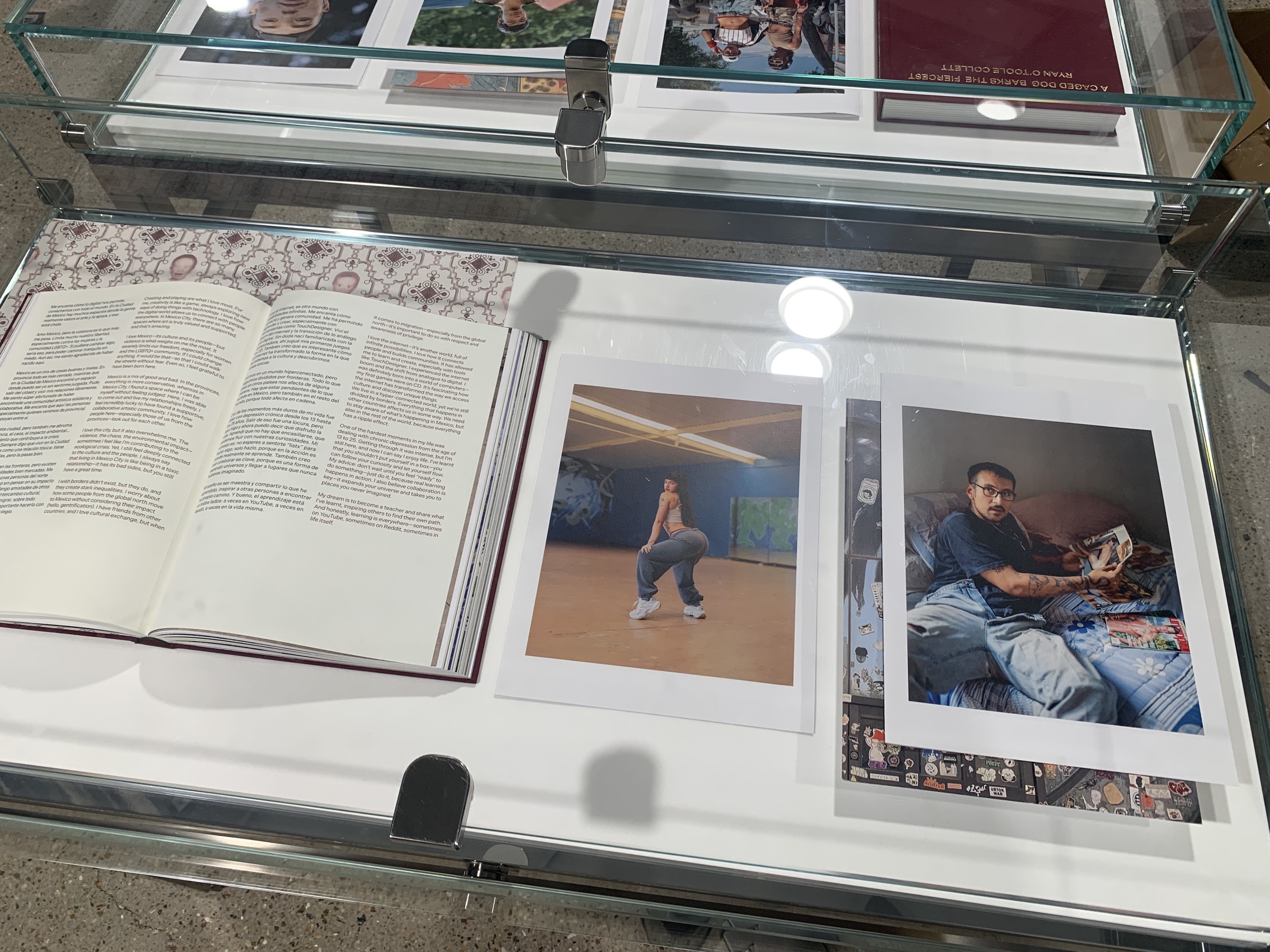 An open copy of A Caged Dog Barks the Fiercest and photographic prints displayed at Dover Street Market London.