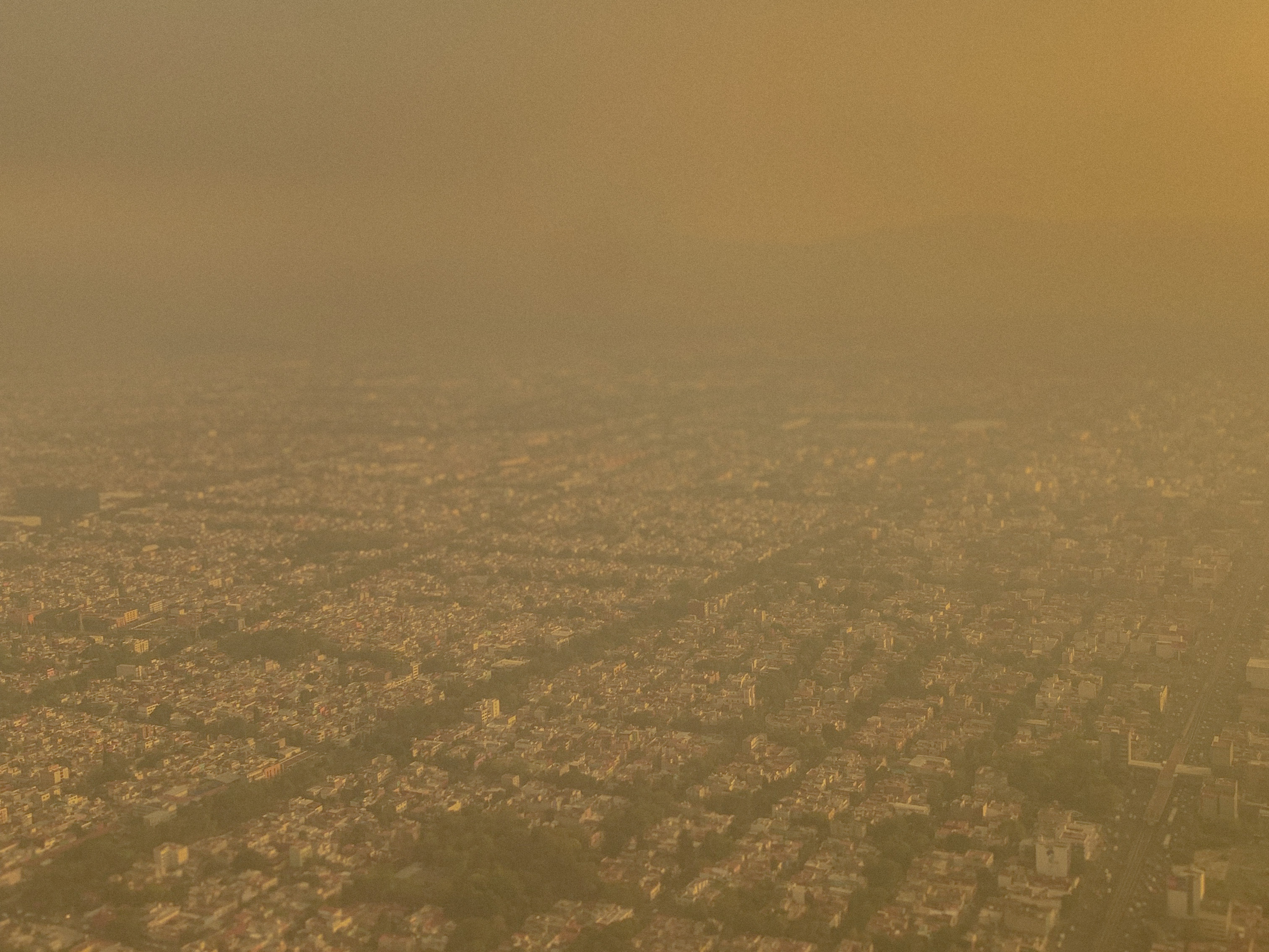 Hazy aerial view across the dense urban landscape of Mexico City, 2024.