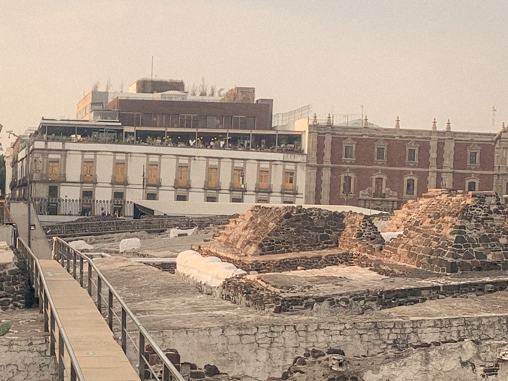 Stone archaeological remains surrounded by city buildings, Mexico City, 2024.
