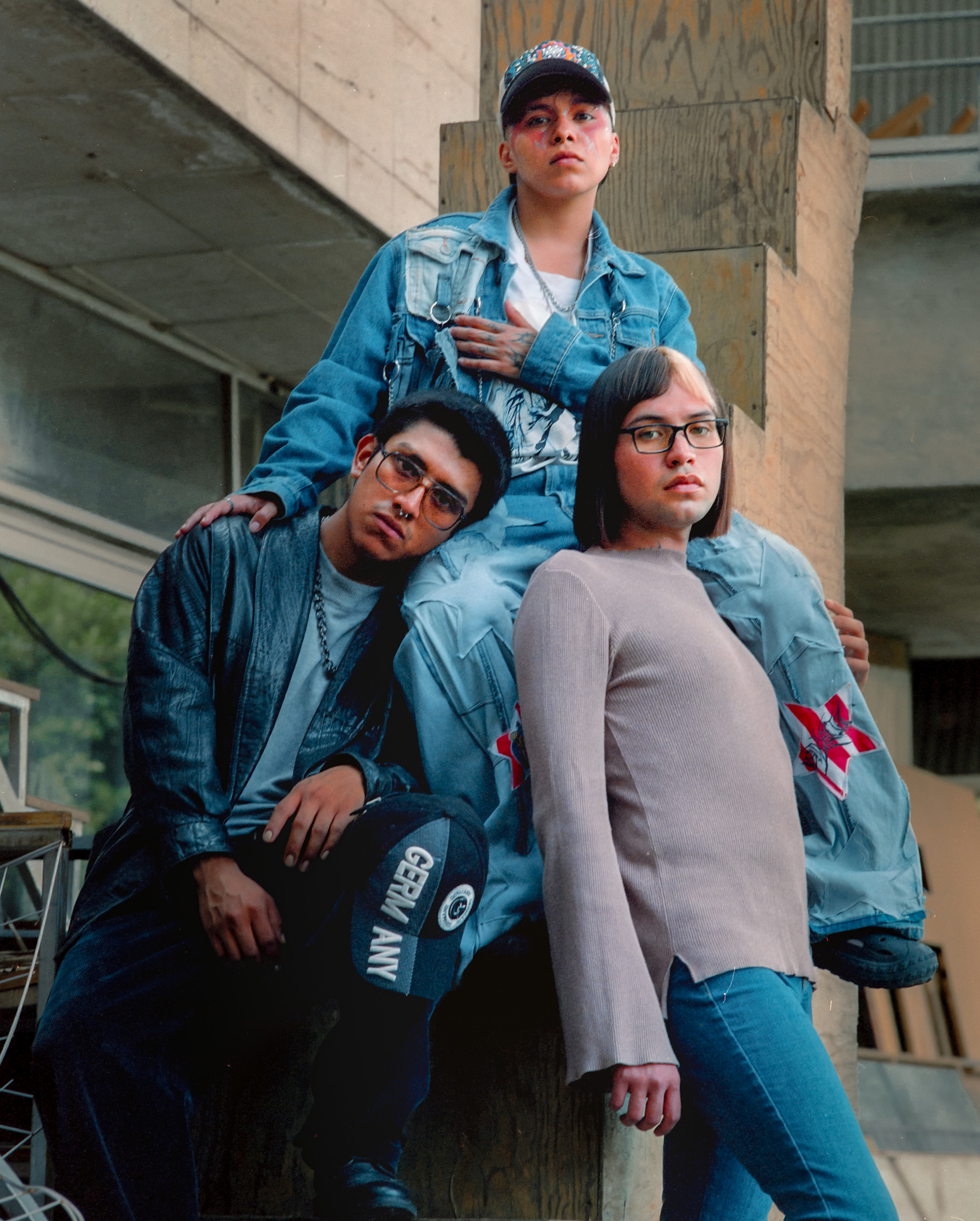 Three people pose together on a concrete structure, Mexico City, 2024.
