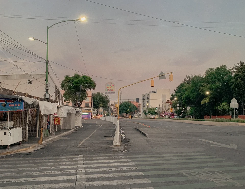 An empty road and suspended traffic lights at dusk, Mexico City, 2024.