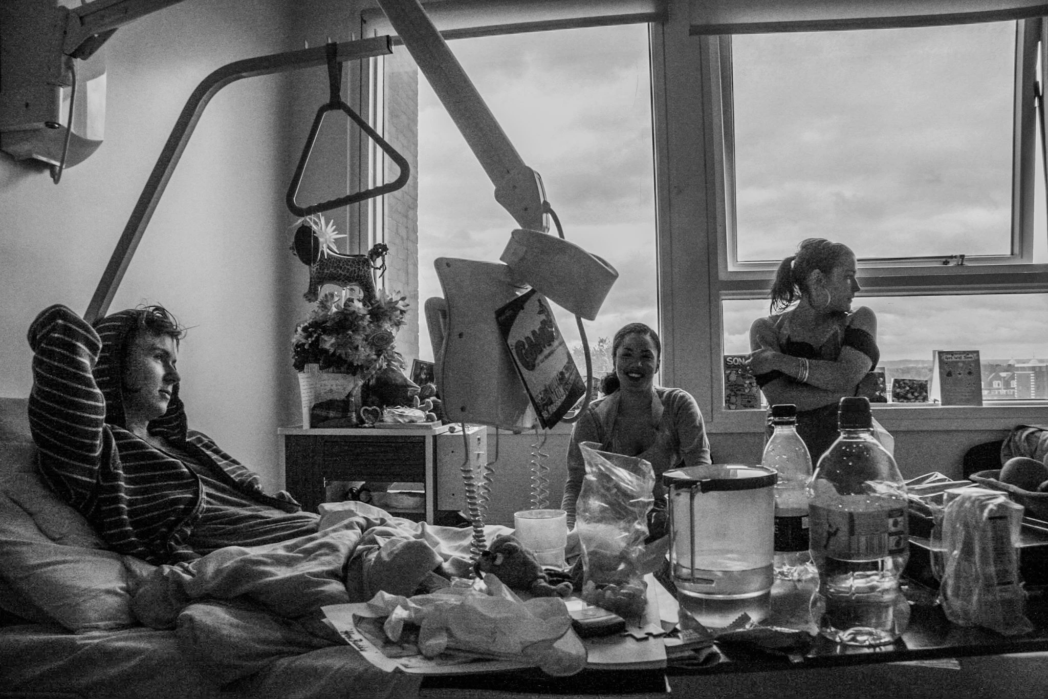 Black-and-white photograph: people gathered around a kitchen table.