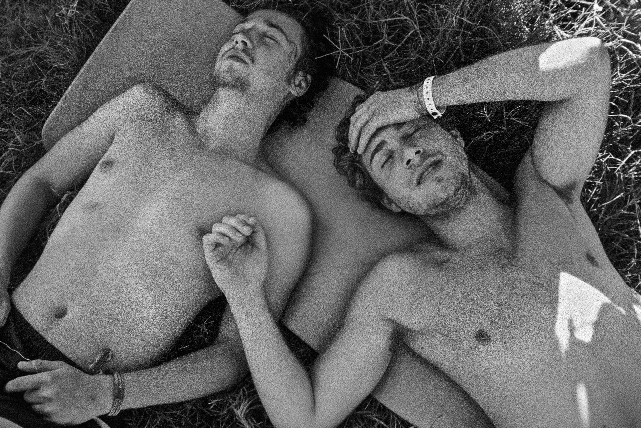 Black-and-white photograph: two people lying together outdoors.