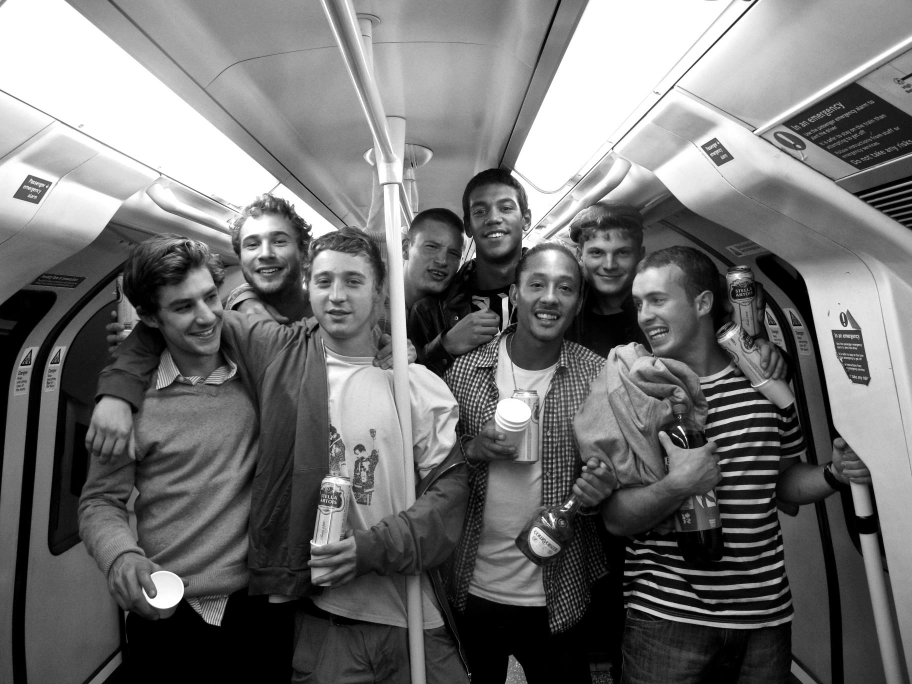 Black-and-white photograph: a group of friends travelling on a train.