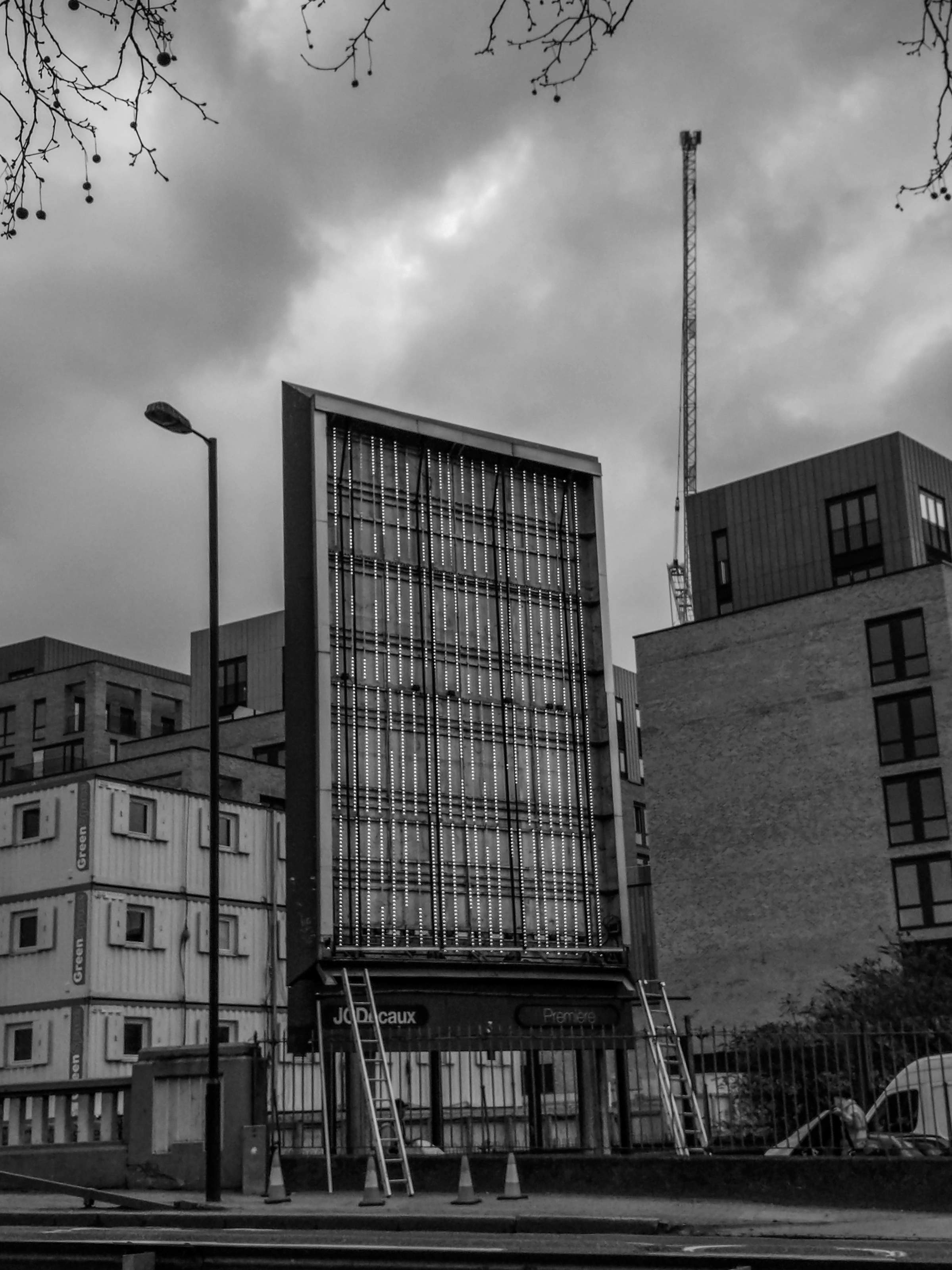 Black-and-white photograph: a tall glass-fronted building seen from the pavement.