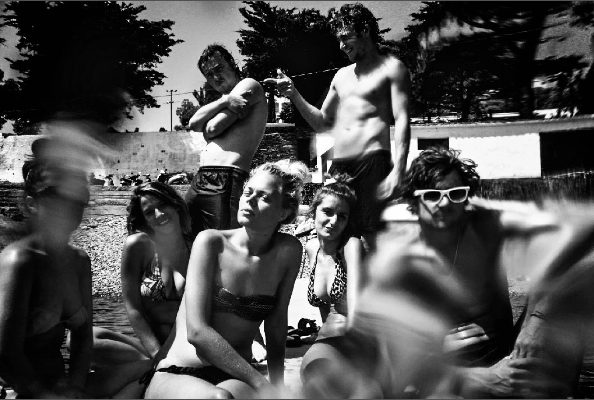 Black-and-white photograph: friends gathered together outdoors.