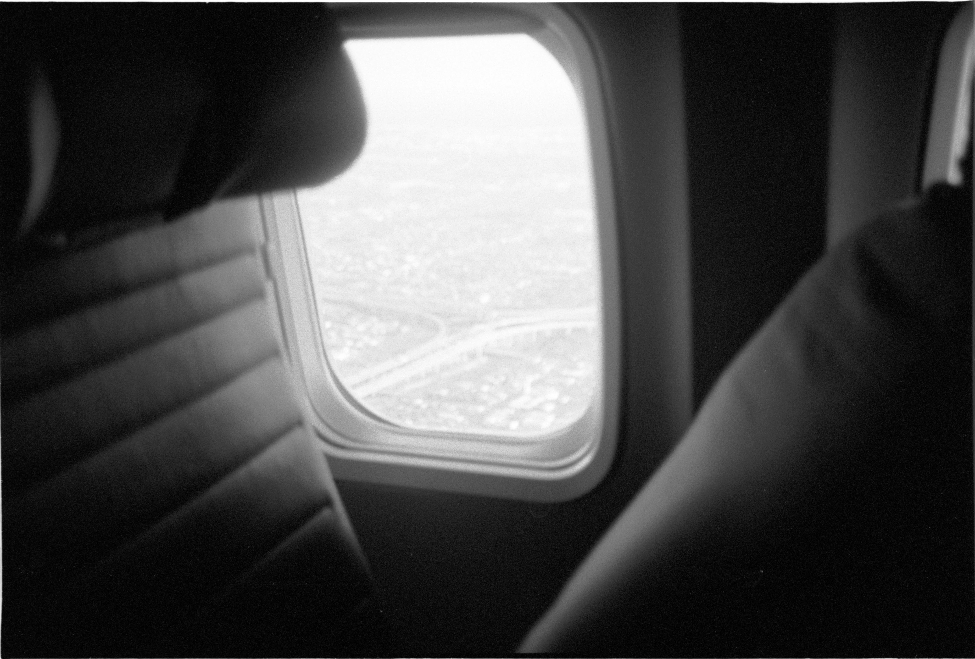 Black-and-white photograph: light entering an aeroplane through a window.