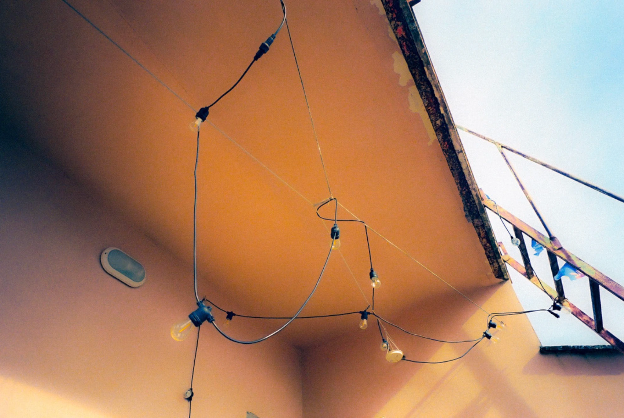 Wiring beneath orange ceiling.