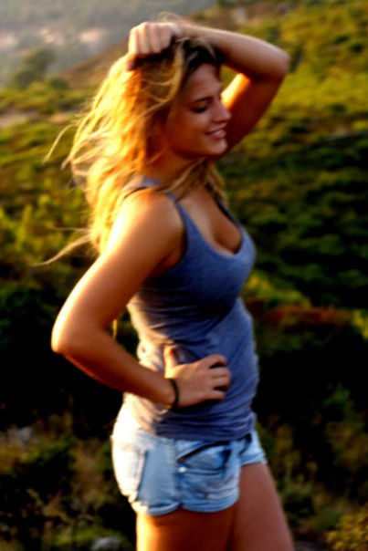 Woman in blue top outdoors.