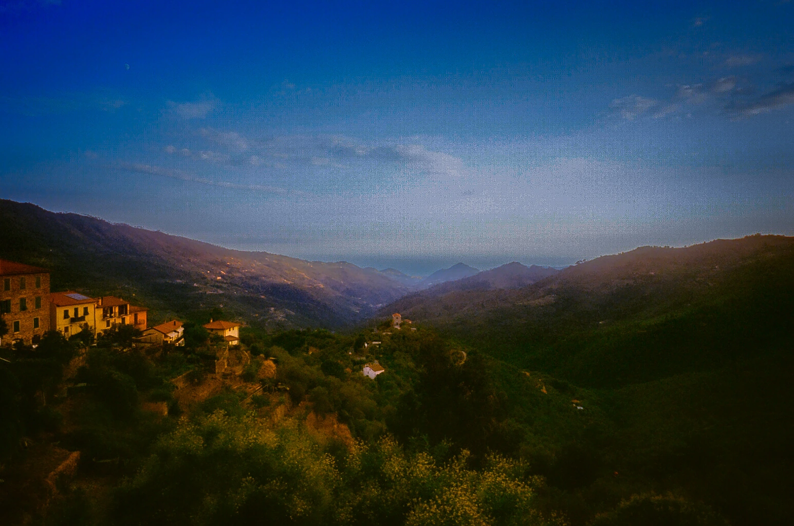 Sunlit town above mountain valley.