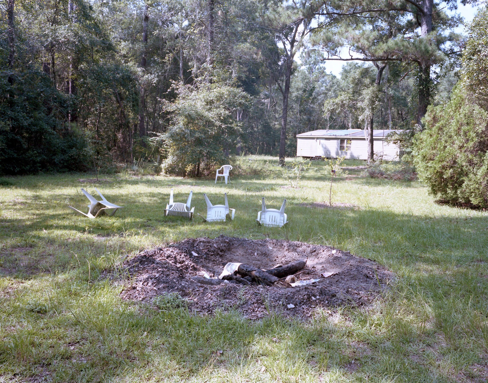 Fire pit and chairs in woodland.