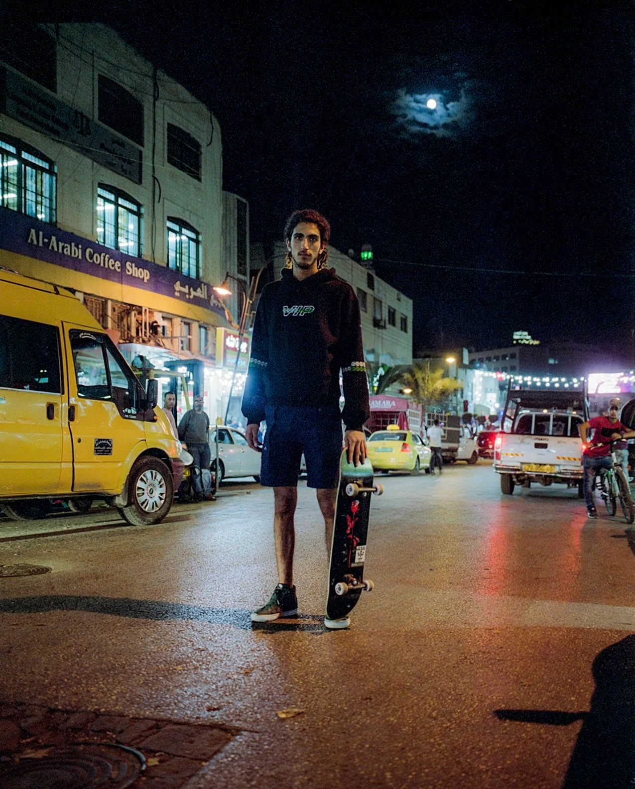 Skateboarder on city street at night.