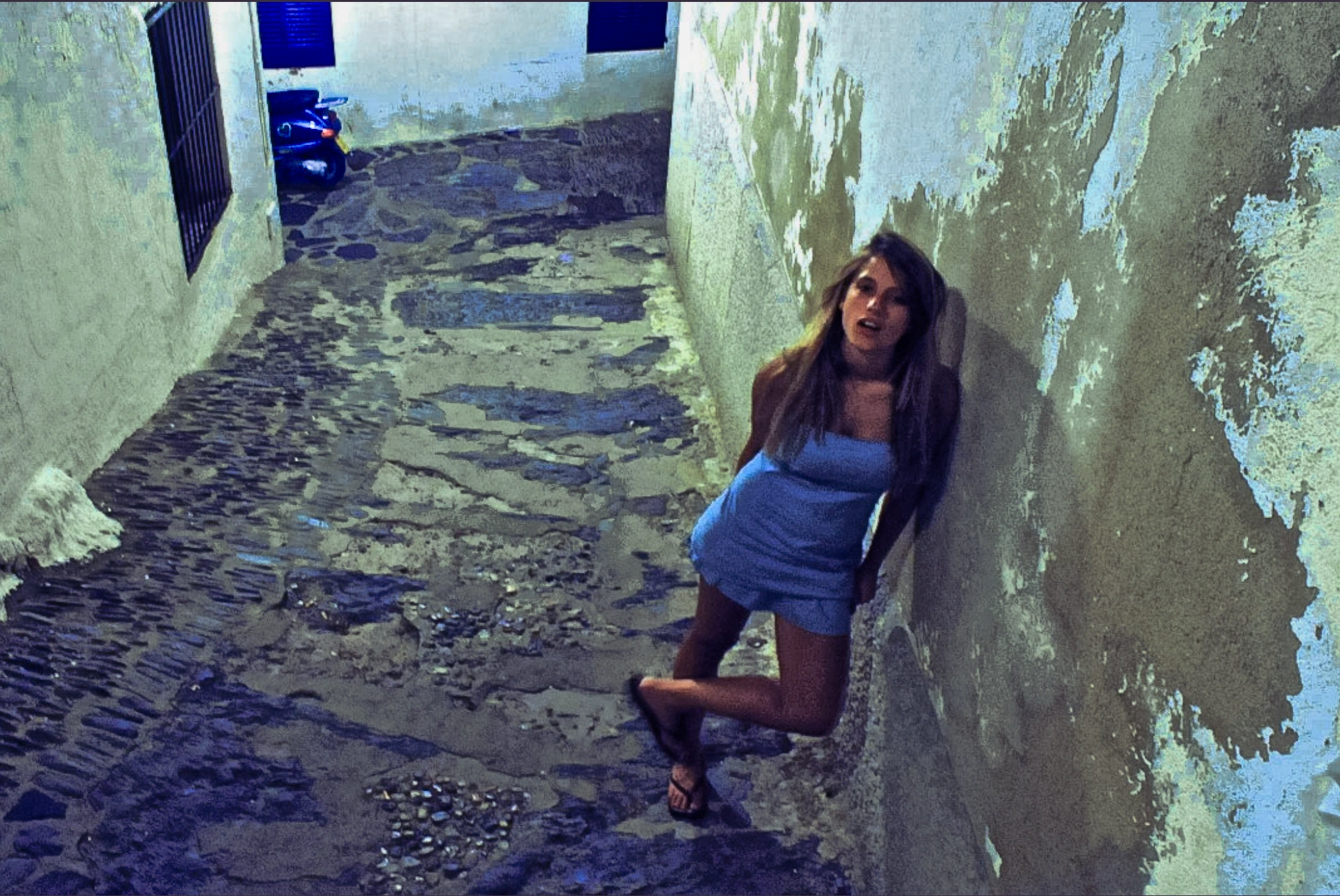 Woman in narrow stone lane.