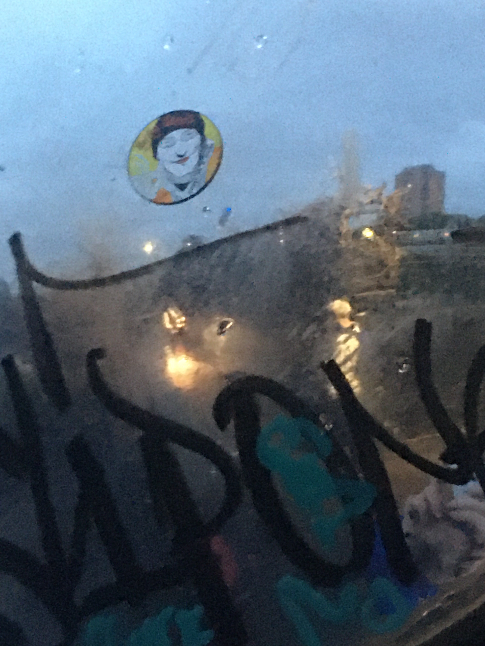 Graffiti on rain-covered window.