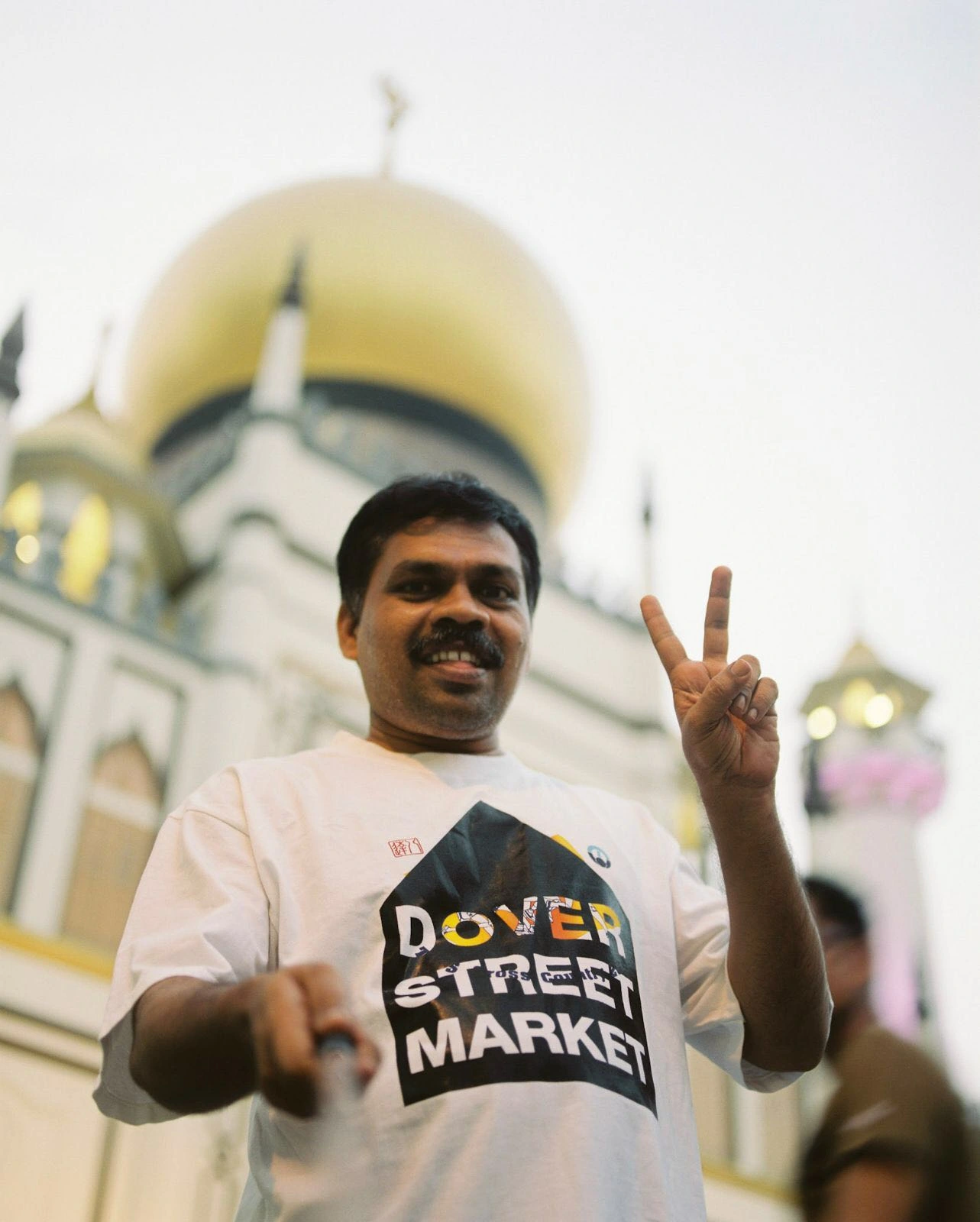 Man outside gold-domed building.