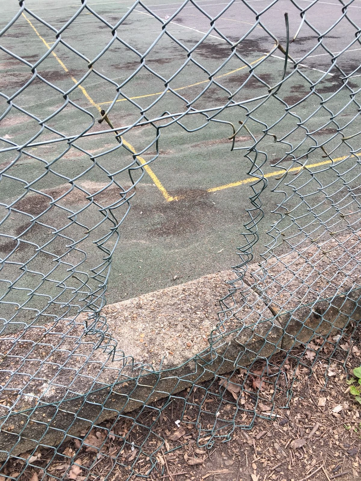 Tennis court through wire fence.