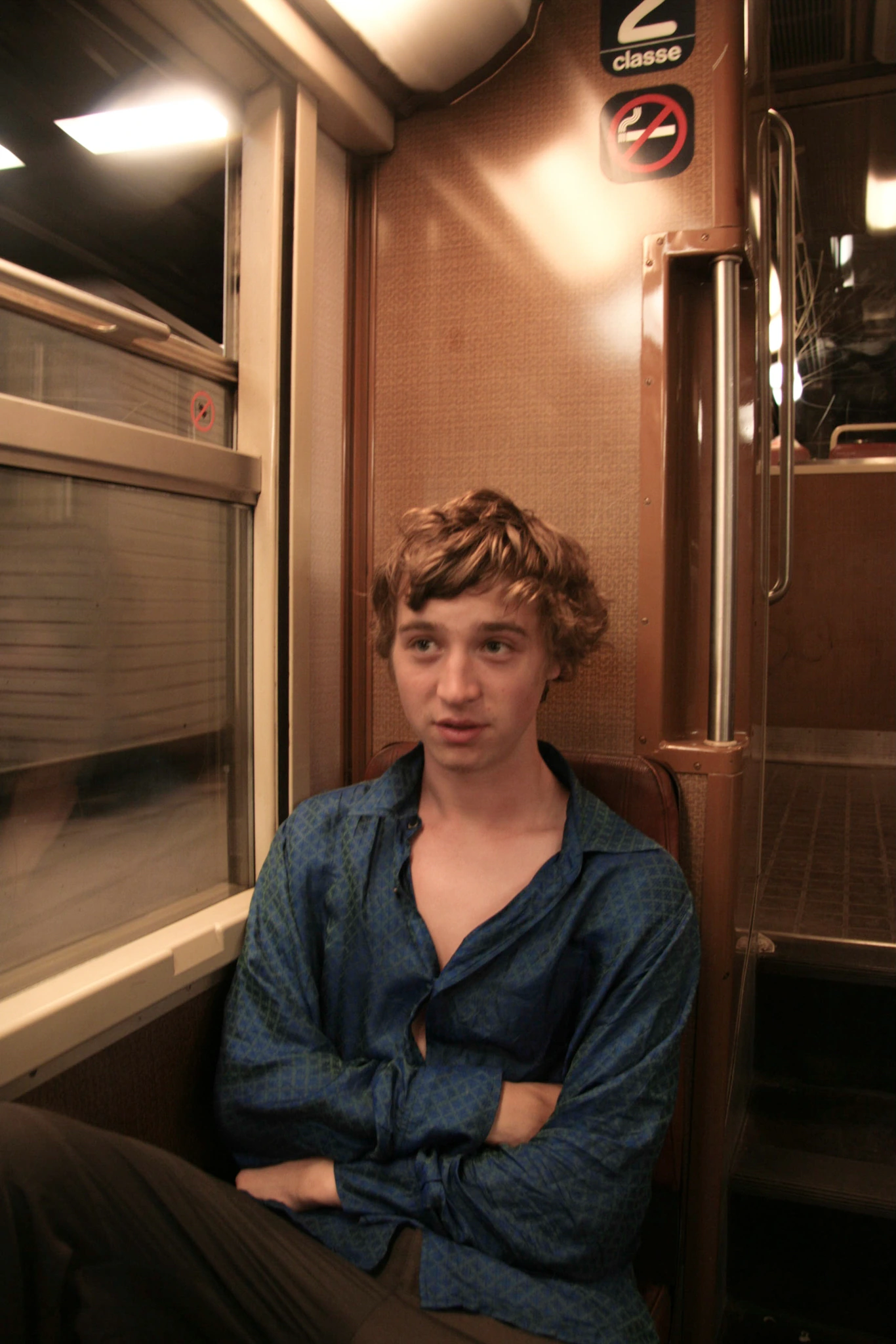 Man seated beside train window.