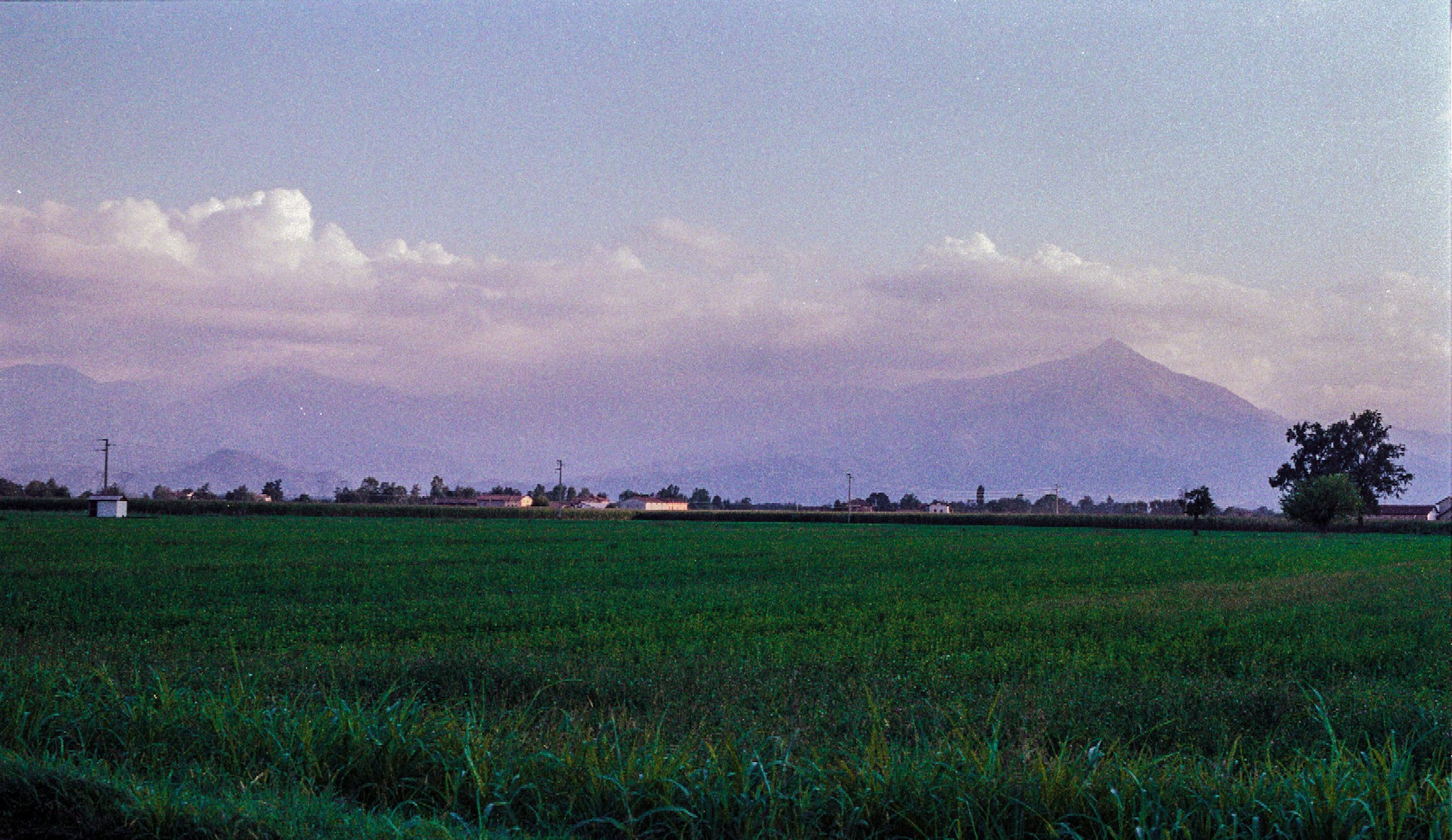 Green field beneath distant mountain.