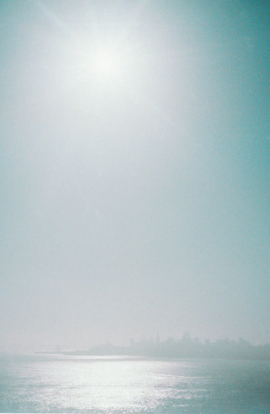 Hazy sun above water.