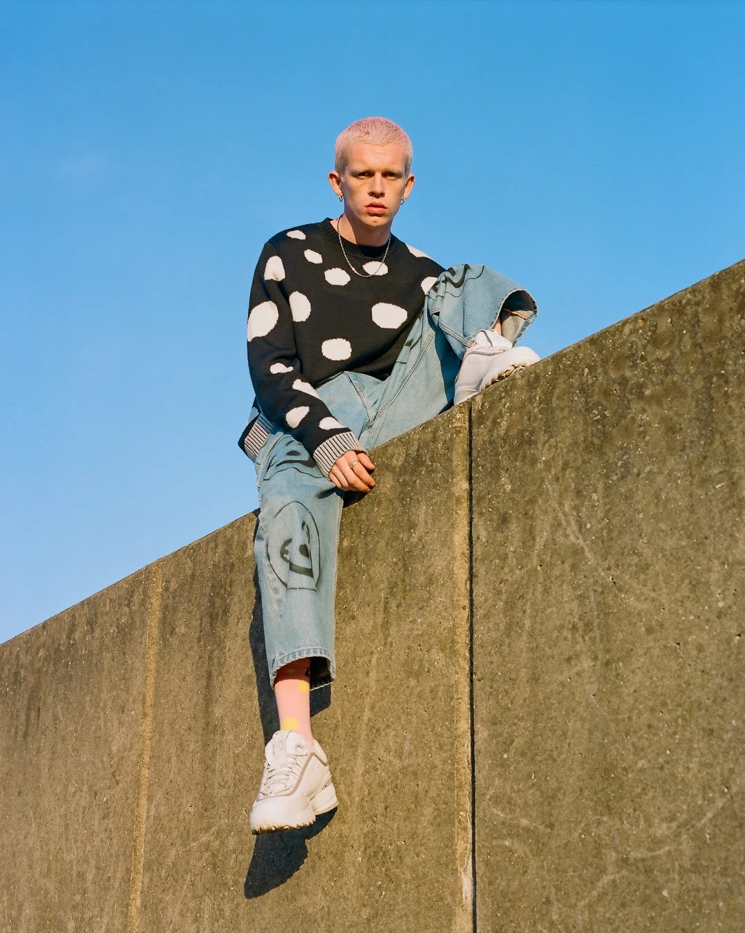 Person perched on concrete wall.