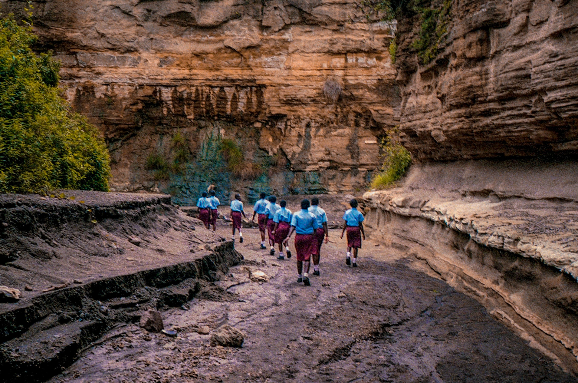 Group walking through rocky gorge.