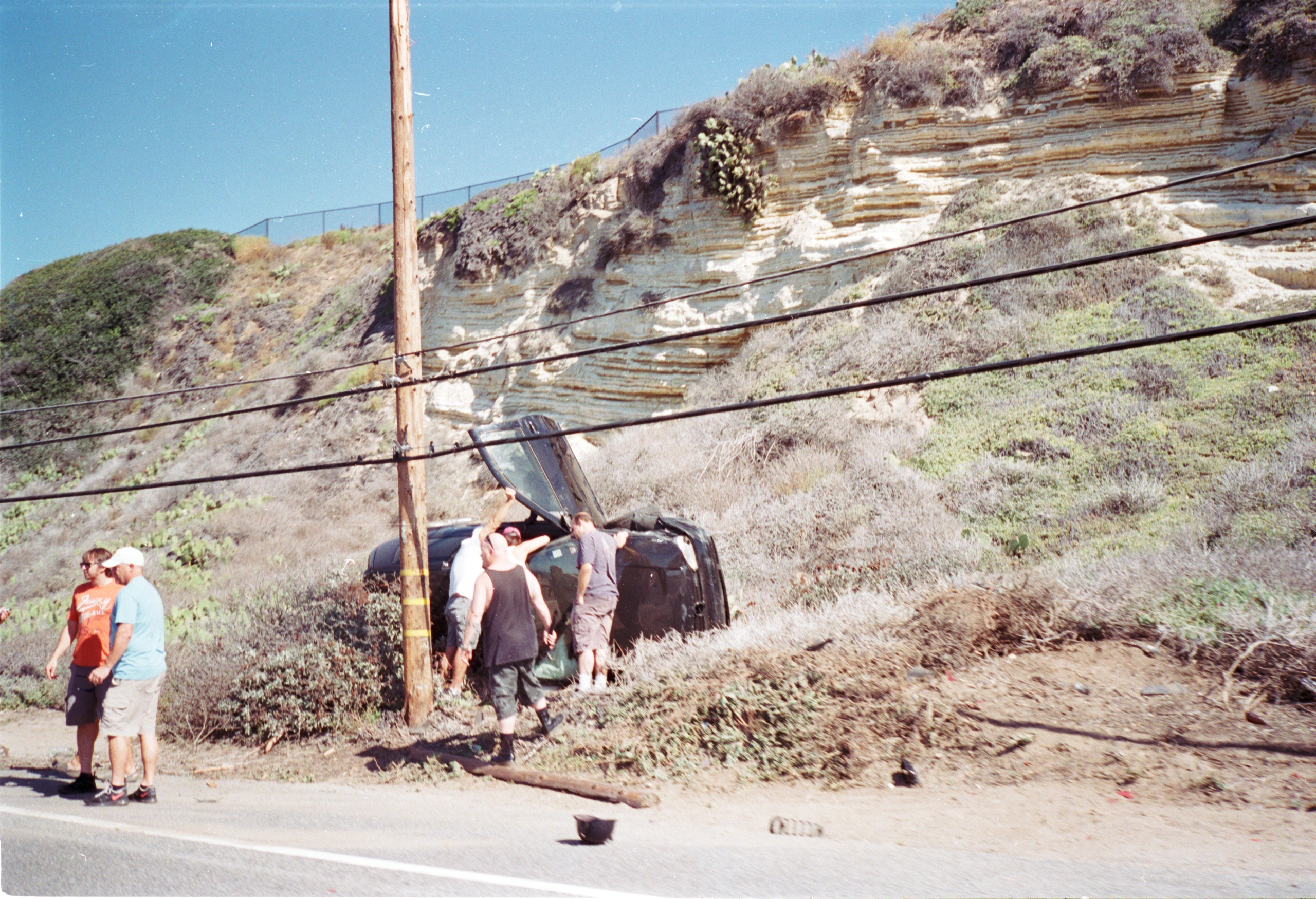 People and donkey beside rocky bank.