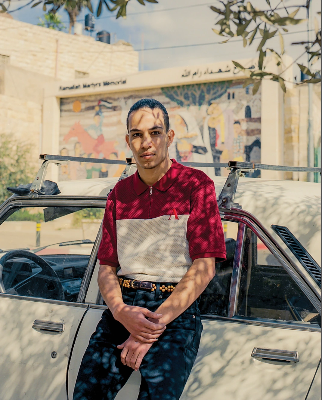 Portrait beside car with tattooed arms.
