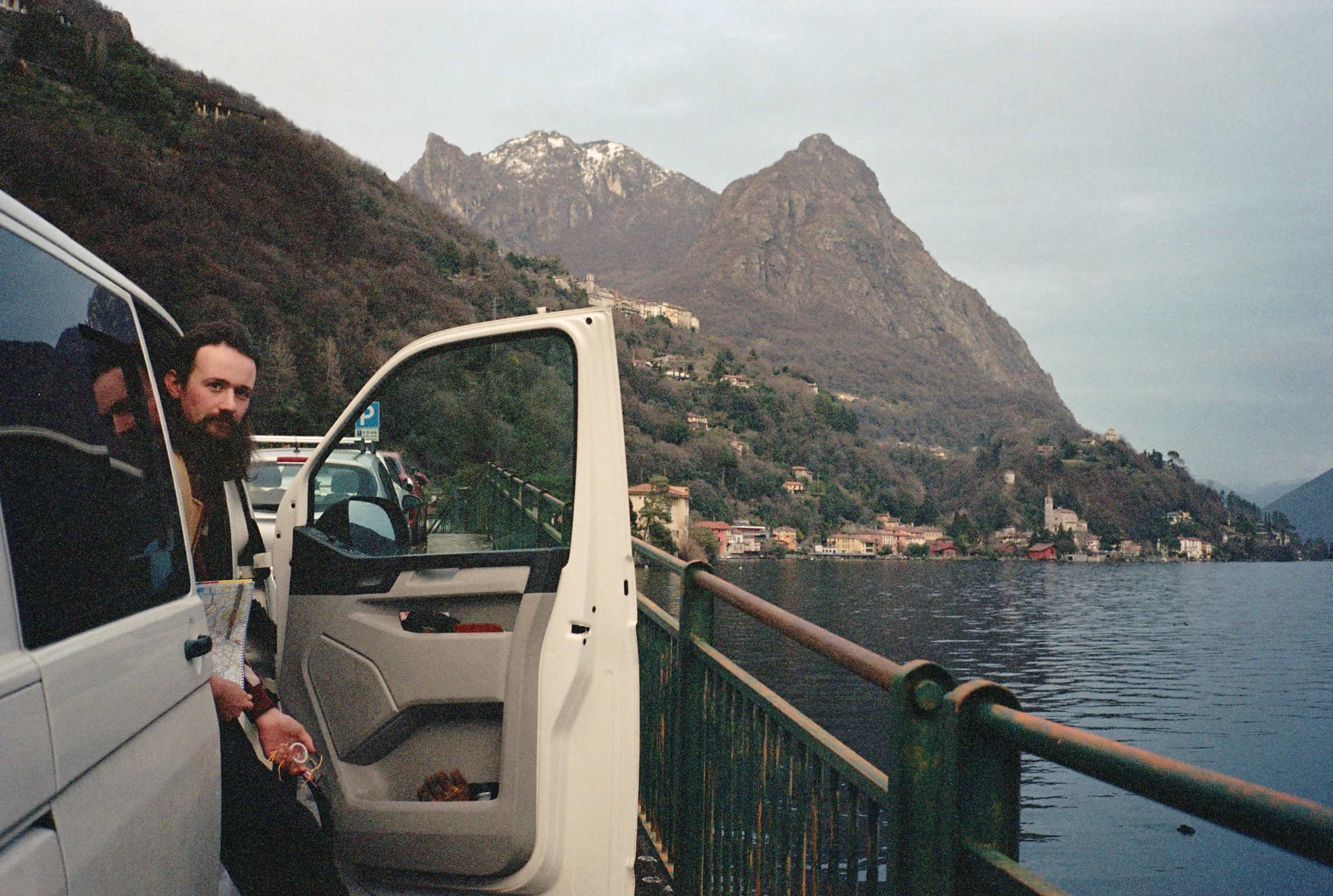 Man beside van overlooking lake.