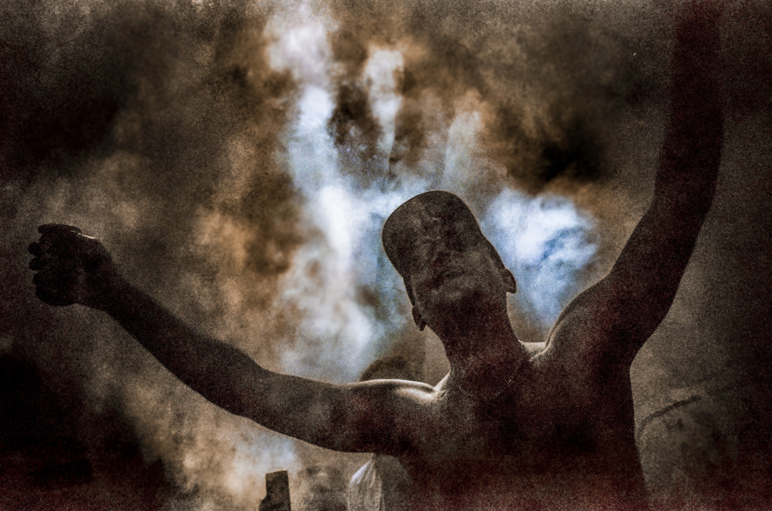 Figure in smoke with raised arms.
