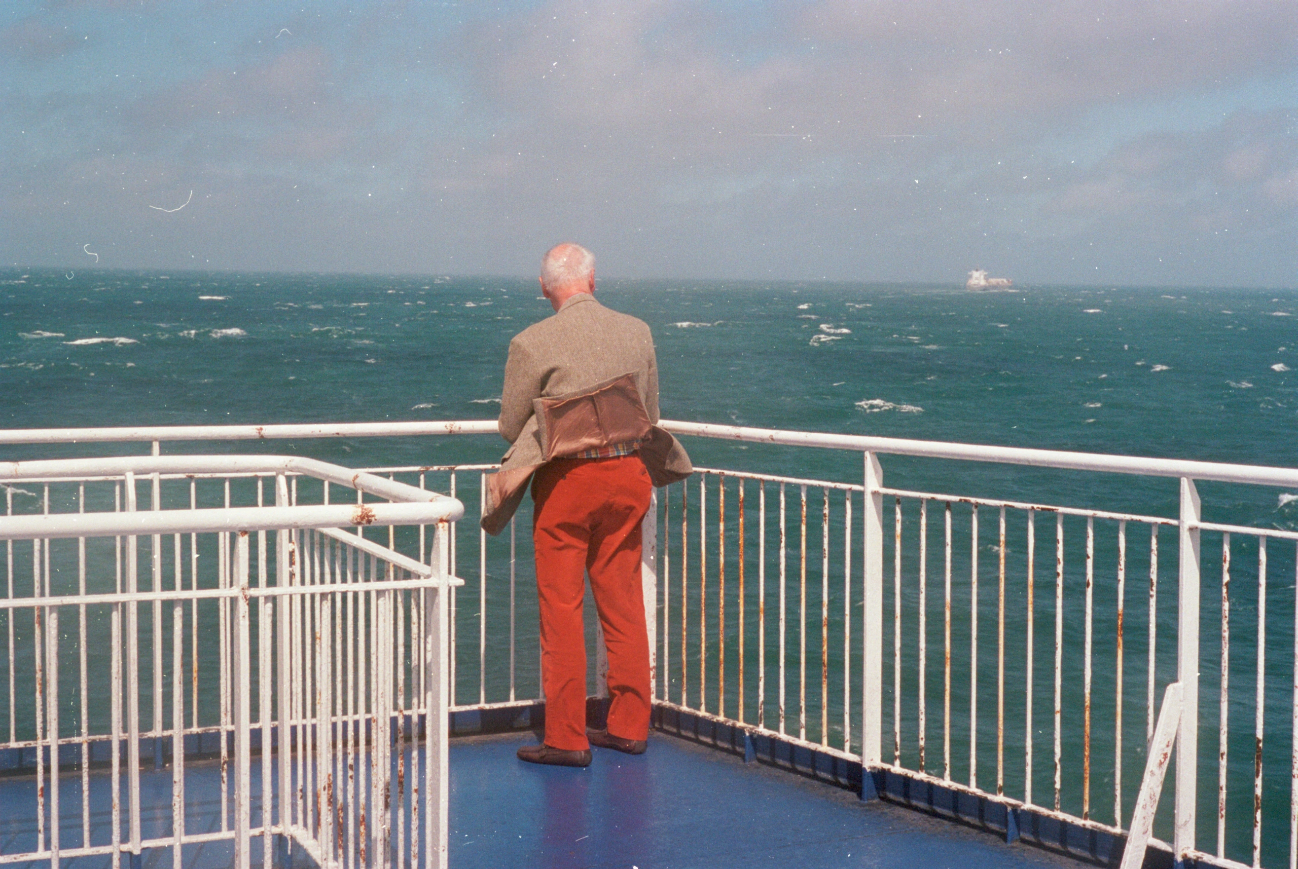 Man looking over ferry railing.