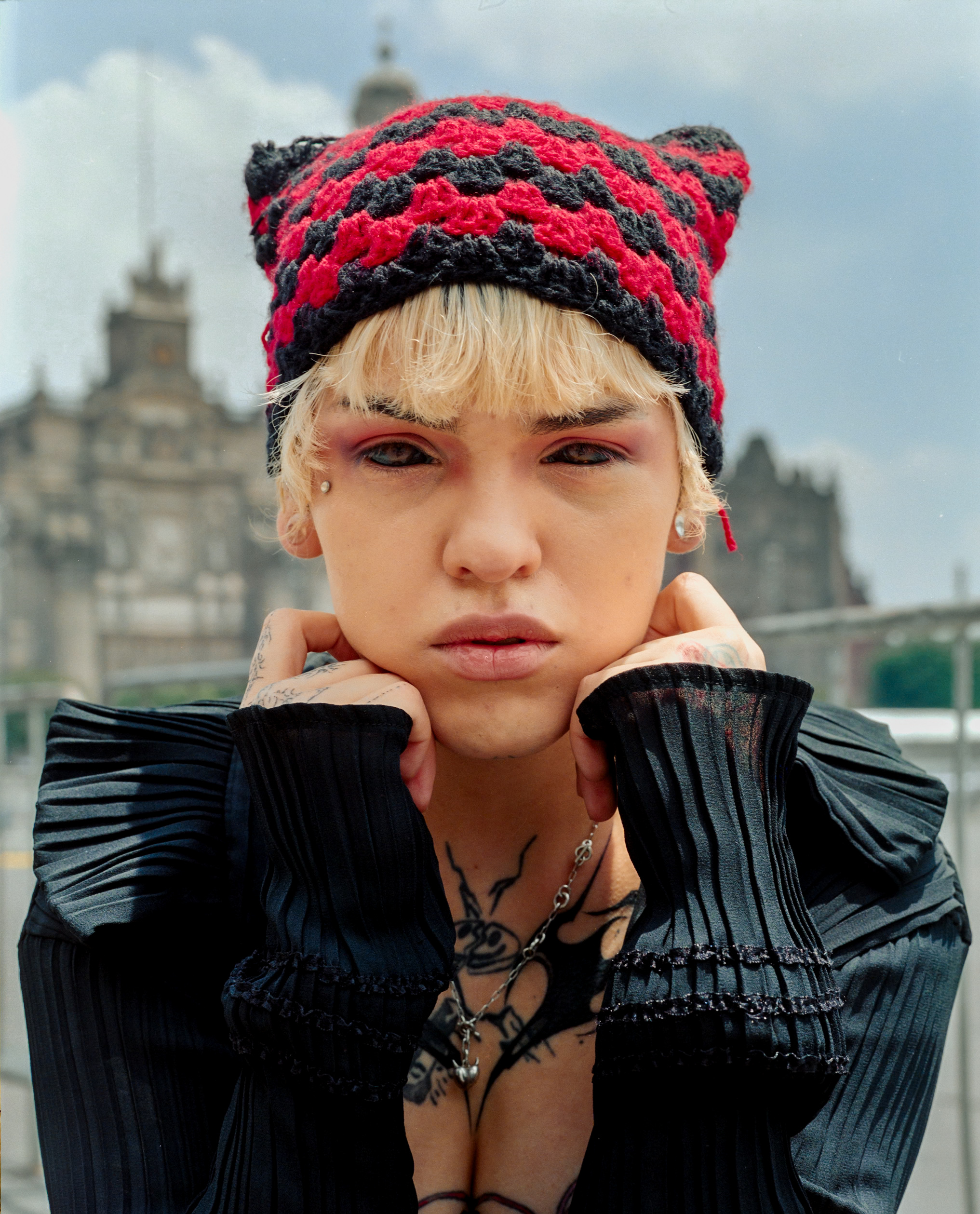 A close portrait in a red and black knitted hat.