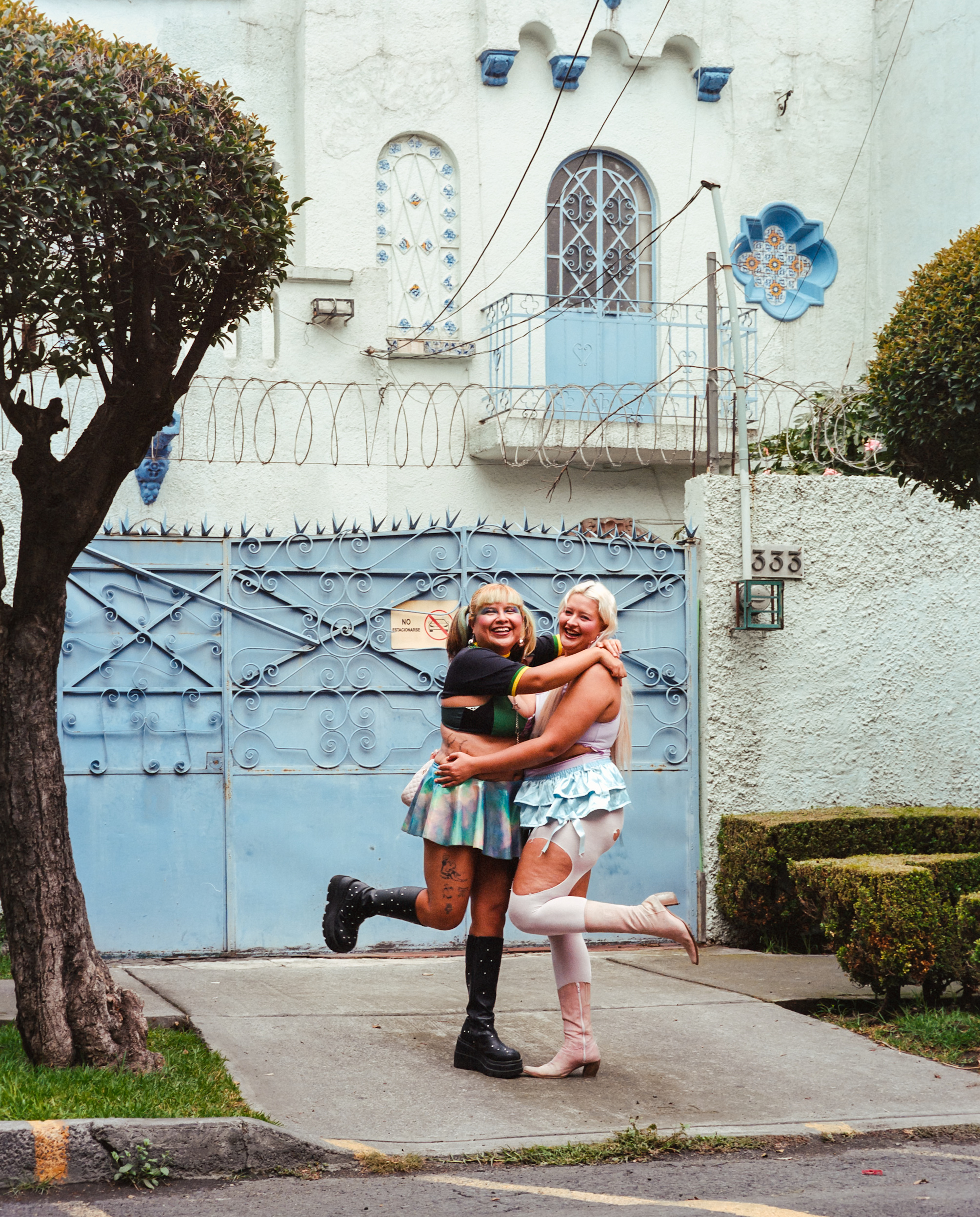 Two people embracing outside a blue gate.