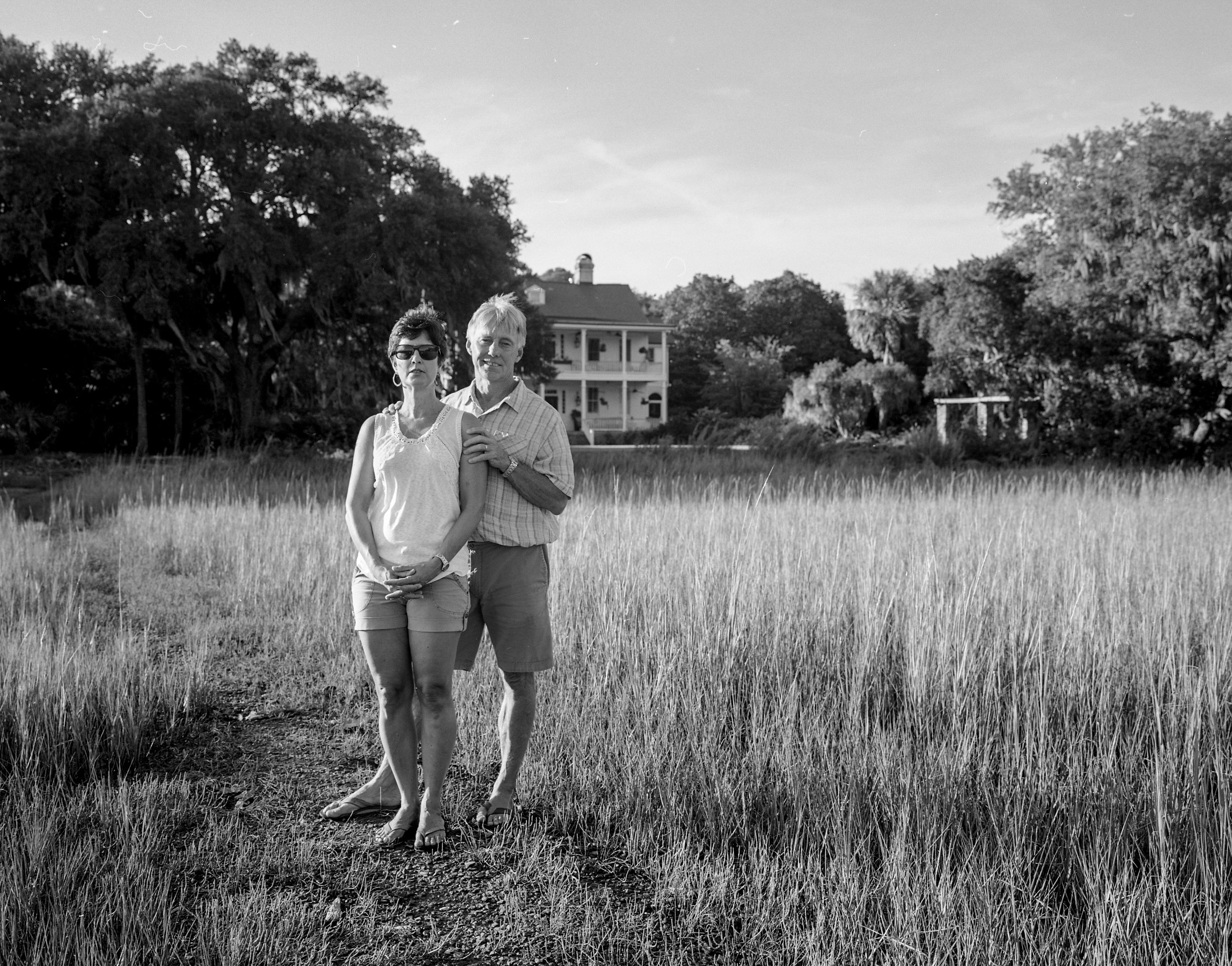Two people standing together in a field, photographed in black and white.