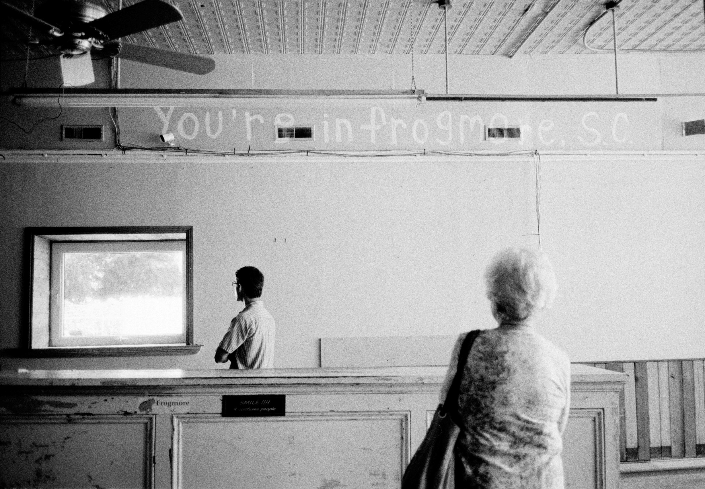 Two people inside a church, photographed in black and white.